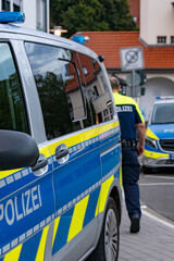 Deutscher Polizist mit zwei Streifenwagen