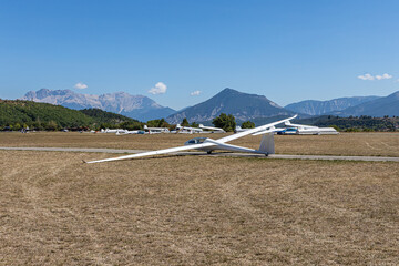 White glider is on the airport on the mountain background