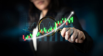 A business professional examines financial graphs and trends with a magnifying glass, emphasizing analysis and strategic insights in a modern digital environment. Impute