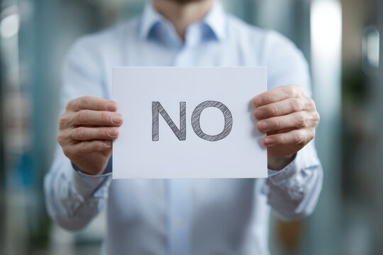 A Person Holding a Sign with the Word 'NO', Expressing Rejection or Dismissal in a Professional Setting
