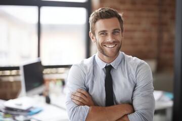Obraz premium Confident smiling businessman in casual dress with arms crossed standing in modern office.