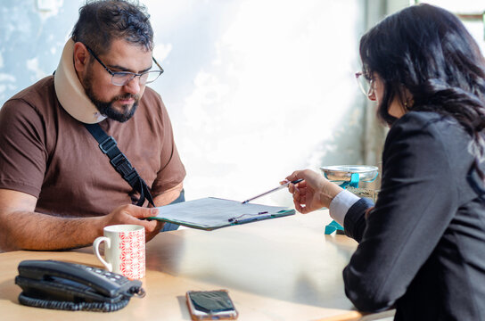 Young female lawyer assist a injured man with legal problem. Lawyer showing document. Compensation for work or car accident. Legal concept. Social Worker. - Powered by Adobe