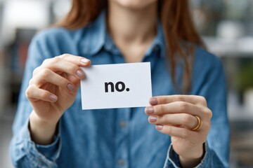 A Person Holding a Card with the Word 'No' Written on It, Emphasizing a Clear Rejection or Negative Response in a Casual Setting