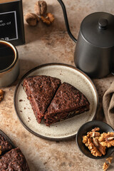 Chocolate spongy brownie cake with walnuts and coffee on brown table background. Two pieces of chocolate brownie cake