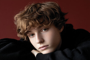 teenager sits with their head resting on their knees lost in deep thoughts and contemplation