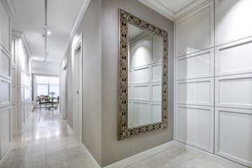 An elegant entrance hall with a large decorative mirror and stylish design elements in a modern interior.