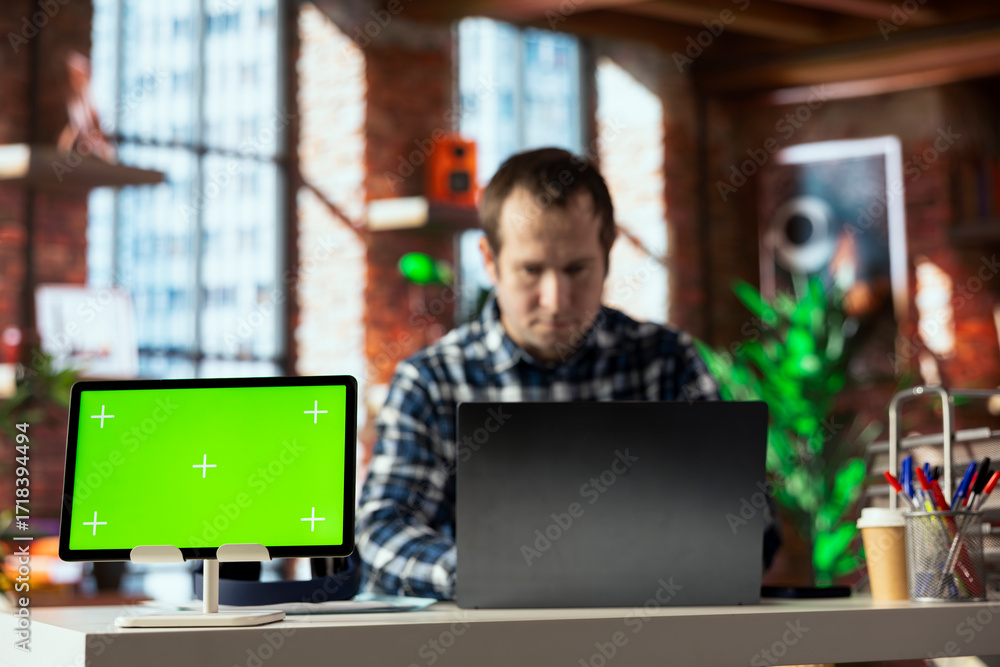 Aufkleber teleworker in home office completing spreadsheets on laptop next to mockup tablet, entering data, ca