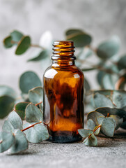 Amber glass bottle surrounded by fresh eucalyptus leaves on a textured surface with a soft natural background for essential oil or wellness concept