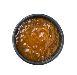 orange jam in a black bowl isolated on white background, top view.