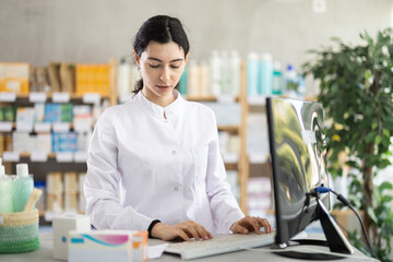 Female pharmacist searches for information about medicines on the Internet