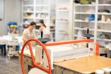 Machine clay press roller is ready for operation in pottery workshop. Mechanism for spreading raw...