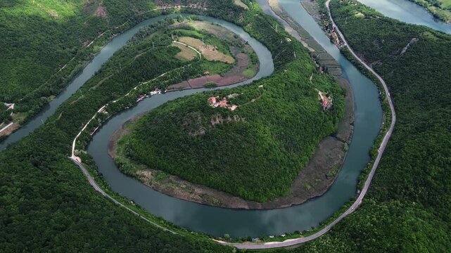 Drone view of a dramatic river bend in Ovcar-Kablar Gorge, Serbia, showing the winding West Morava River surrounded by lush green hills. Horizontal 4k footage