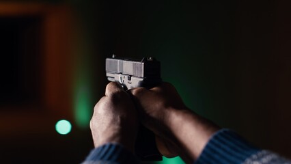 Shooting gallery client using handgun to hit paper targets with ammo. Close up shot of person...