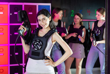 Portrait of happy cheerful girl with a laser gun for playing laser tag