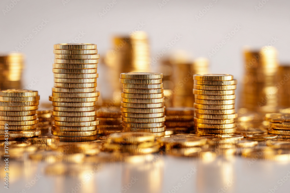 Poster close-up of multiple neatly stacked golden coins symbolizing financial growth, savings, and wealth a
