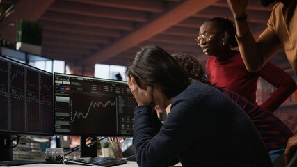 Startup team concerned by company stock valuation dropping, signaling future funding challenges. Venture management distraught by financial decline leading to budget cuts and layoffs, camera A