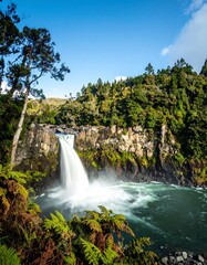 Fototapeta premium Waterfall cascading into a tranquil pool, surrounded by lush greenery
