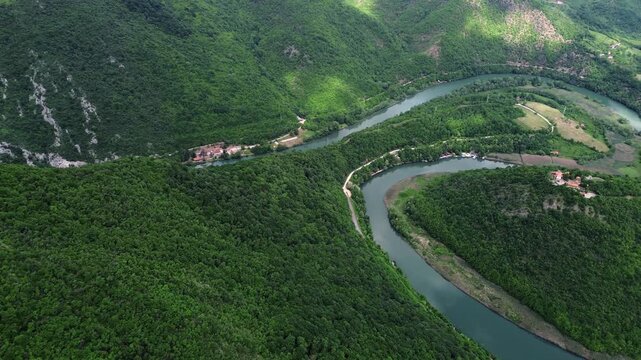 Drone view of a dramatic river bend in Ovcar-Kablar Gorge, Serbia, showing the winding West Morava River surrounded by lush green hills. Horizontal 4k footage