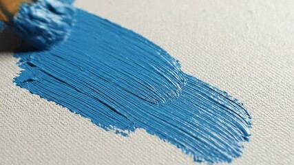 Close up of blue paint brush stroke on canvas texture.