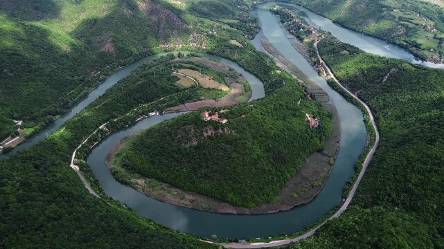 Drone view of a dramatic river bend in Ovcar-Kablar Gorge, Serbia, showing the winding West Morava River surrounded by lush green hills. Horizontal 4k footage