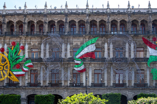 A building with a lot of windows and a lot of decorations on it. The decorations are in the shape of people and there are a lot of them. Decoration to celebrate Independence Day in Mexico, zocalo