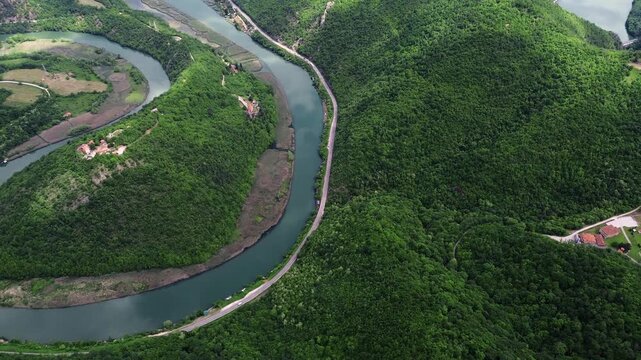 Drone view of a dramatic river bend in Ovcar-Kablar Gorge, Serbia, showing the winding West Morava River surrounded by lush green hills. Horizontal 4k footage