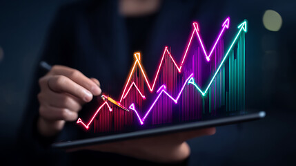 Person analyzing a colorful digital graph on a tablet displaying financial growth trends