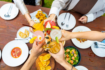 Group of Happy Asian people diverse friends enjoy and fun celebration meeting social gathering dinner party eating food, drinking cocktail and talking together in the garden at restaurant in evening.