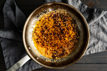 Freshly Made Chili Crisp Oil in a Skillet: Red Chili flakes and fresh garlic cooked in a stainless steel frying pan with melted butter