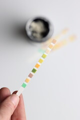 Urinalysis strips to test urine sample in a light background and copy space