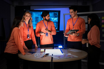 A cybersecurity team in a Security Operations Center analyzes a global threat map. They are collaborating on an incident response, tracking network intrusions in real-time.