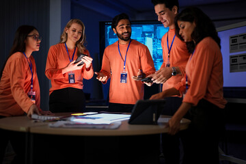 A successful team of app developers proudly presents their completed project. The diverse group is happy with the results of their hard work and effective collaboration.