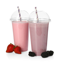 Milkshakes of different flavors in plastic cups and ingredients isolated on white