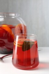 Tasty fruity punch on white table. Refreshing drink