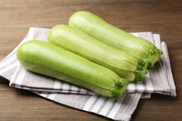 Fresh ripe zucchinis on wooden table, closeup