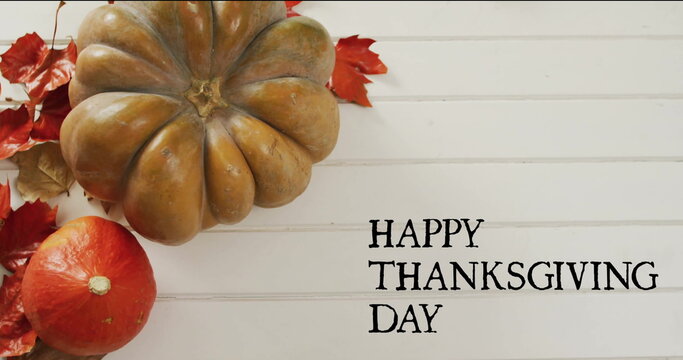 Fototapeta Image of happy thanksgiving day text over autumn pumpkins on white wooden boards