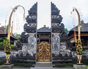 Balinese split gate with gold ornate door and penjor decorations