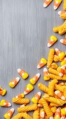 Obraz premium Halloween wooden sign background with candy corn and spiral pasta creating festive and playful seasonal scene