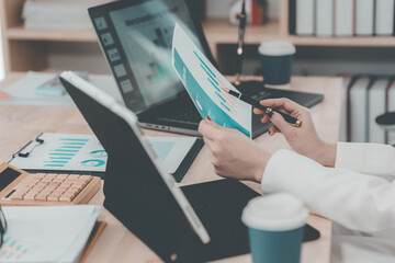 Two businesswomen having a meeting and looking at financial data, charts and graphs on a digital...
