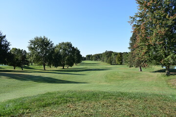Manicured golf course fairway on a bright and sunny summer afternoon.