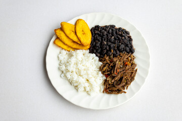 Delicious Venezuelan pabellón criollo with rice, beans, shredded beef, plantain and fried egg. Authentic Latin food photography