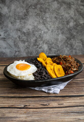 Delicious Venezuelan pabellón criollo with rice, beans, shredded beef, plantain and fried egg. Authentic Latin food photography