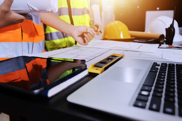 Closeup of team of industrial engineers meeting analyze machinery blueprints consult project on...