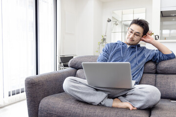 ソファーでノートパソコンを使う男性
