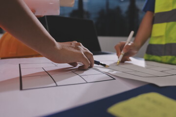 Closeup of team of industrial engineers meeting analyze machinery blueprints consult project on table in manufacturing factory. Working in manufacturing plant or production plant.