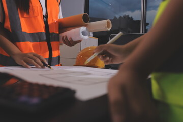 Closeup of team of industrial engineers meeting analyze machinery blueprints consult project on table in manufacturing factory. Working in manufacturing plant or production plant.
