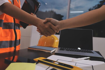Closeup of team of industrial engineers meeting analyze machinery blueprints consult project on table in manufacturing factory. Working in manufacturing plant or production plant.