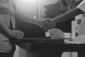 Closeup of team of industrial engineers meeting analyze machinery blueprints consult project on table in manufacturing factory. Working in manufacturing plant or production plant.