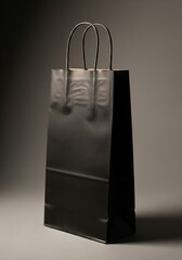 Isolated Black Paper Bag with Twisted Handles on Gray Background Still Life