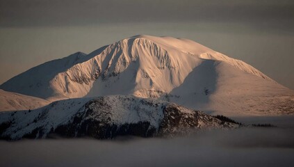 Snow-capped mountain peak above a misty valley